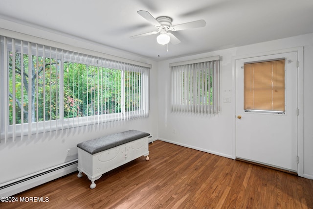 sitting room featuring wood-type flooring, baseboard heating, and ceiling fan