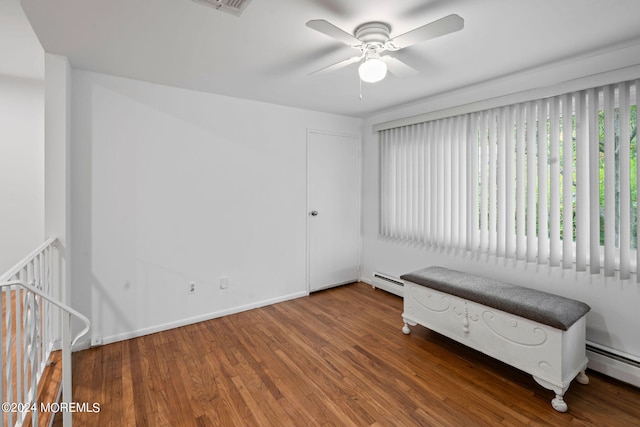 interior space featuring wood-type flooring, ceiling fan, and a baseboard radiator