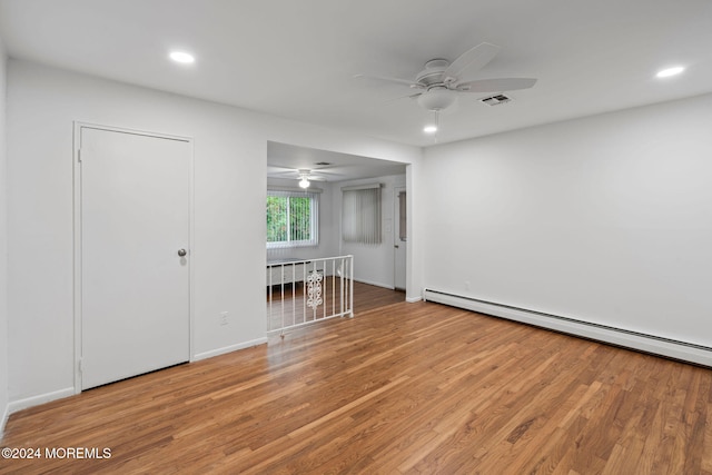 unfurnished bedroom featuring a baseboard heating unit, ceiling fan, and hardwood / wood-style flooring