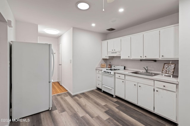 kitchen with white cabinets, white appliances, light hardwood / wood-style floors, and sink