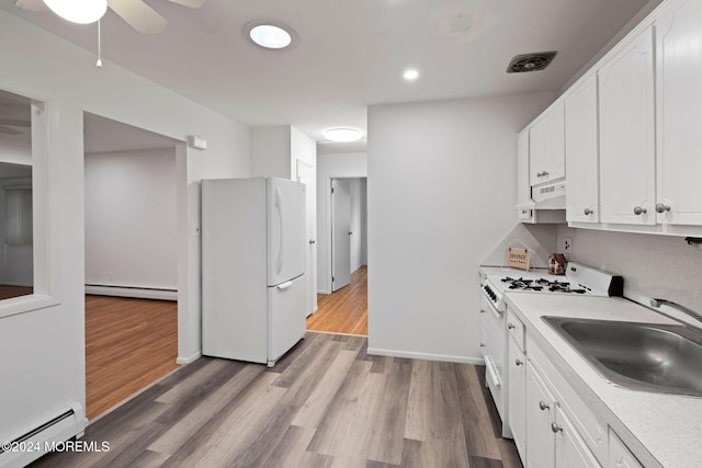 kitchen featuring white appliances, white cabinetry, baseboard heating, and exhaust hood