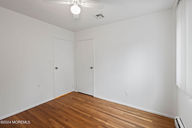 spare room featuring ceiling fan, a baseboard radiator, and hardwood / wood-style floors