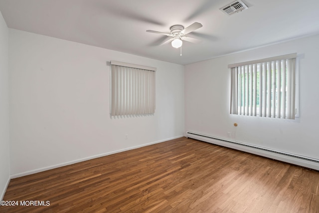 spare room with ceiling fan, baseboard heating, and hardwood / wood-style floors