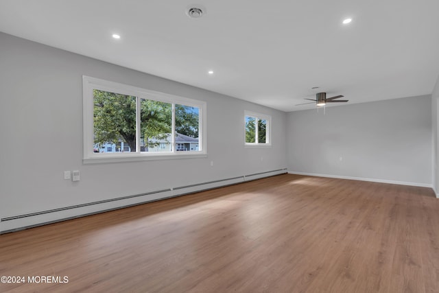 spare room with baseboard heating, light hardwood / wood-style flooring, and ceiling fan