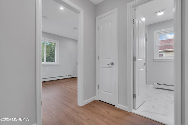 corridor featuring light wood-type flooring and a baseboard radiator