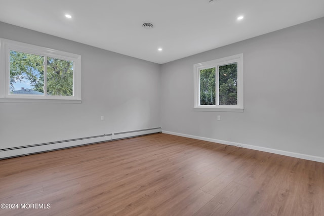 spare room featuring a baseboard radiator and light wood-type flooring