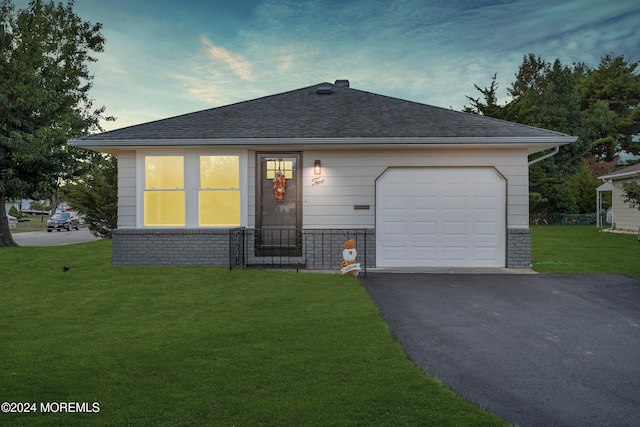 view of front of property with a yard and a garage