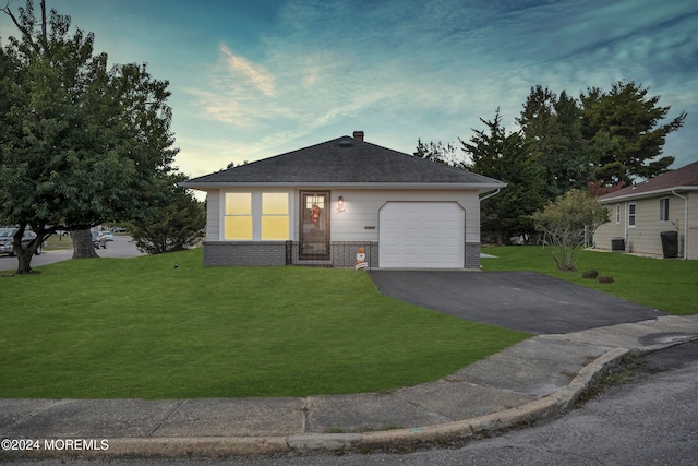 view of front of home with a yard and a garage