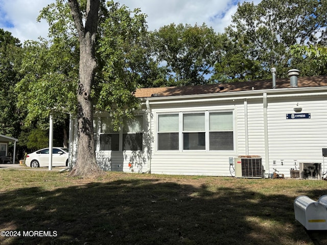 view of home's exterior featuring a lawn and central AC