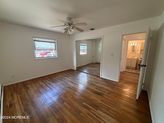 interior space featuring a baseboard heating unit, ceiling fan, and dark hardwood / wood-style flooring