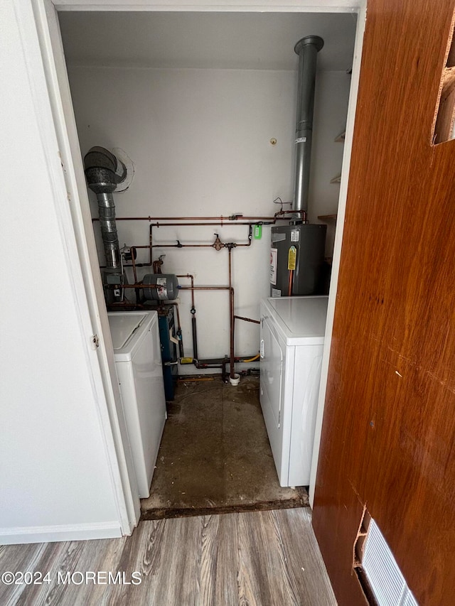 washroom with gas water heater, dark wood-type flooring, and washing machine and dryer