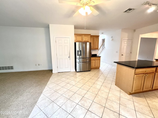 kitchen with visible vents, ceiling fan, dark countertops, and stainless steel fridge with ice dispenser