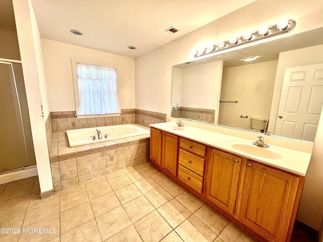 full bathroom featuring visible vents, a sink, a garden tub, and double vanity