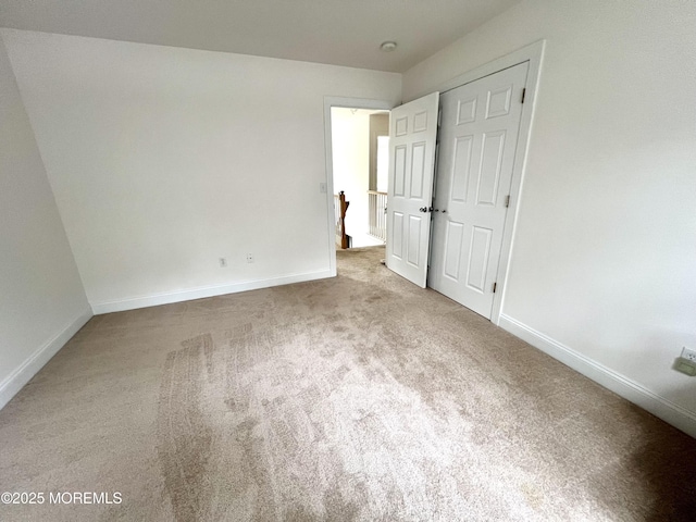 unfurnished bedroom featuring baseboards and carpet
