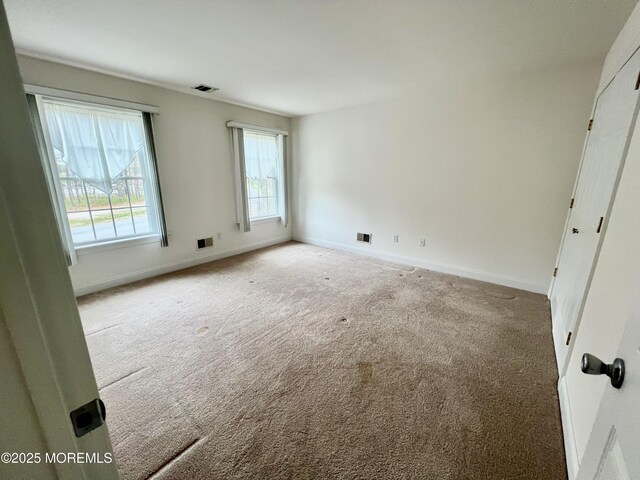 unfurnished bedroom with baseboards, carpet flooring, and visible vents