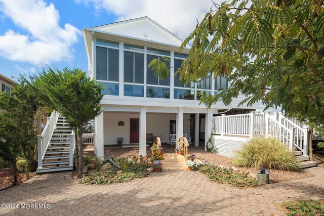 view of front facade with a sunroom and covered porch