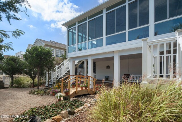 back of property with a sunroom and a patio area