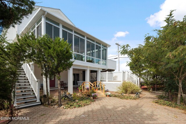 view of side of property with a sunroom and a patio