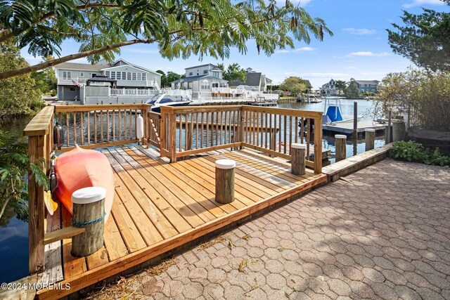 dock area with a patio and a deck with water view