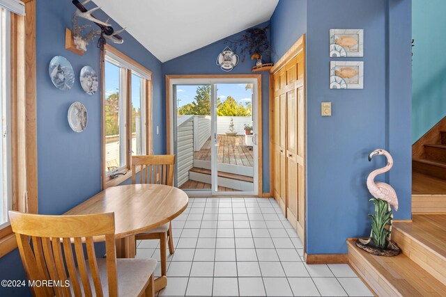 tiled dining area featuring lofted ceiling