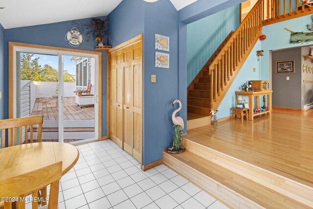 entrance foyer with wood-type flooring and vaulted ceiling