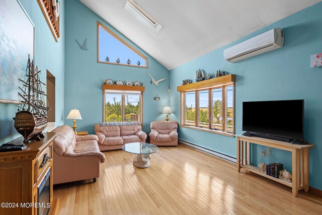 living room with a skylight, high vaulted ceiling, a baseboard radiator, light wood-type flooring, and an AC wall unit