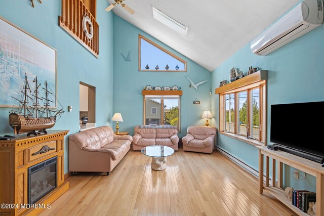 living room featuring high vaulted ceiling, light hardwood / wood-style floors, plenty of natural light, and a wall mounted AC