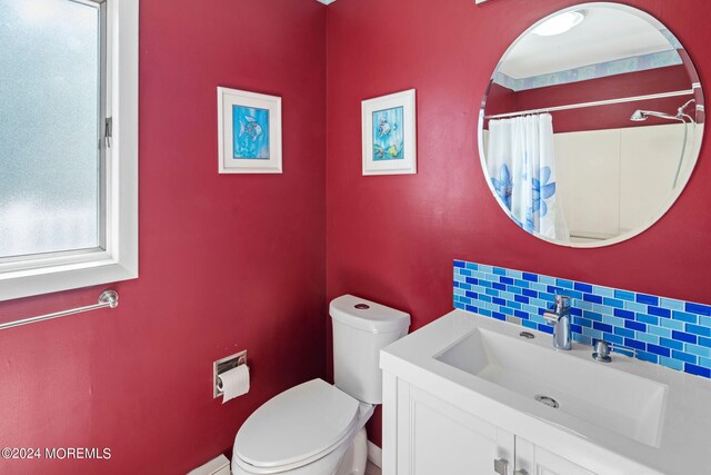 bathroom featuring walk in shower, backsplash, vanity, and toilet