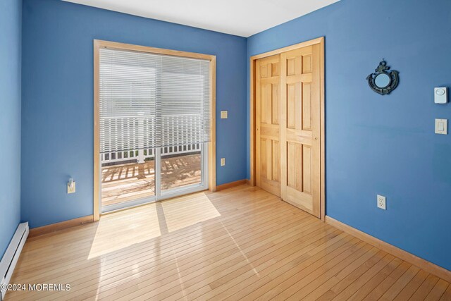 spare room with light wood-type flooring and baseboard heating