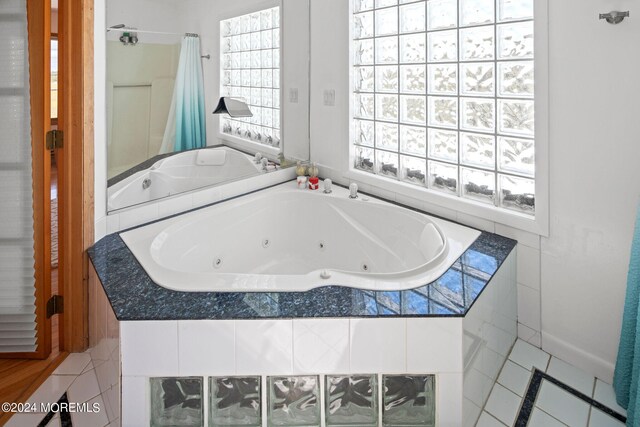 bathroom with tiled bath and tile patterned floors