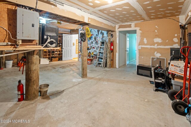 basement featuring electric panel and a workshop area