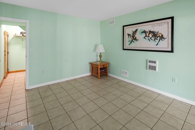 tiled spare room with heating unit