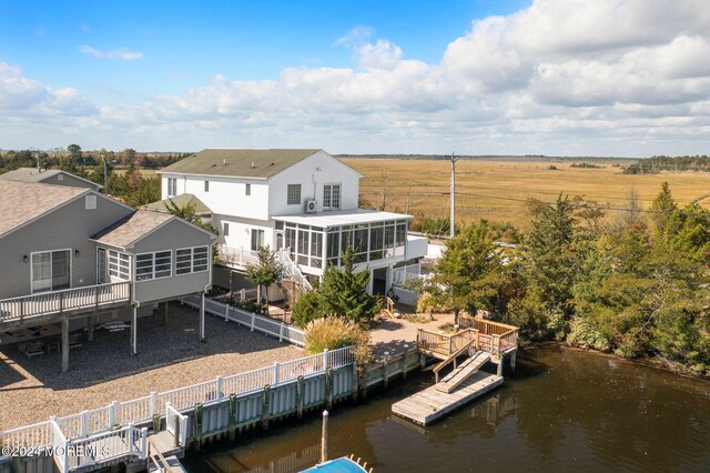 back of house featuring a sunroom and a deck with water view