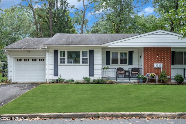 ranch-style house with a front yard, a garage, and covered porch