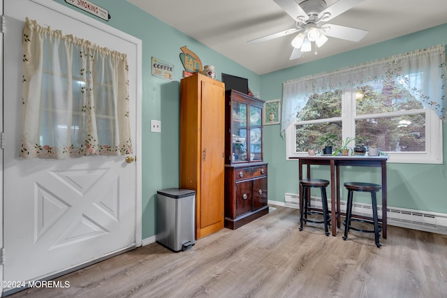 dining space featuring baseboard heating, ceiling fan, and light hardwood / wood-style flooring