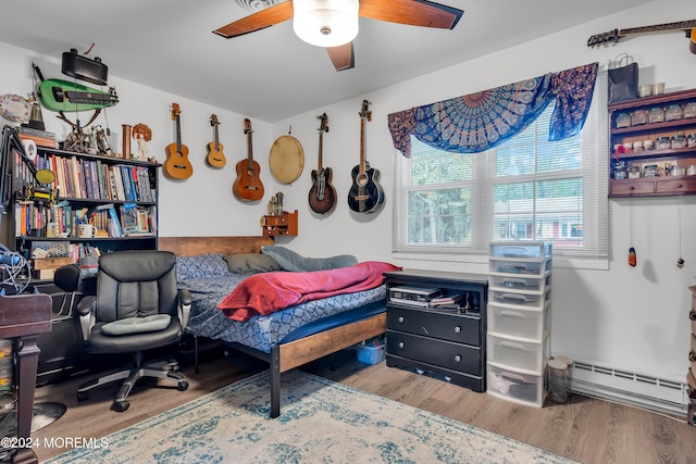 bedroom featuring ceiling fan, baseboard heating, and hardwood / wood-style floors