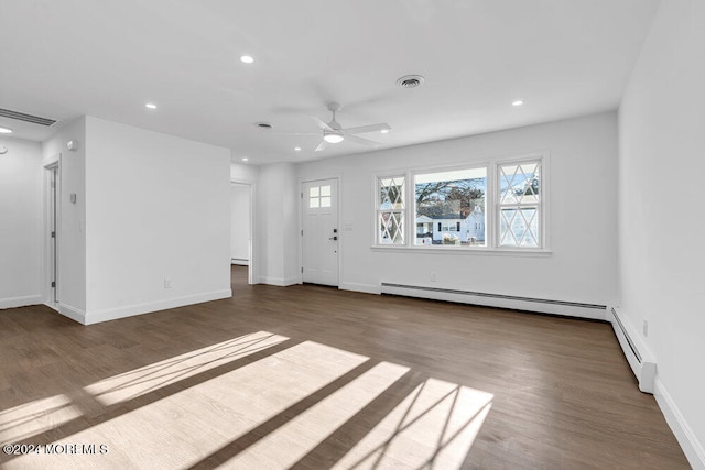 unfurnished living room featuring ceiling fan, baseboard heating, and dark wood-type flooring