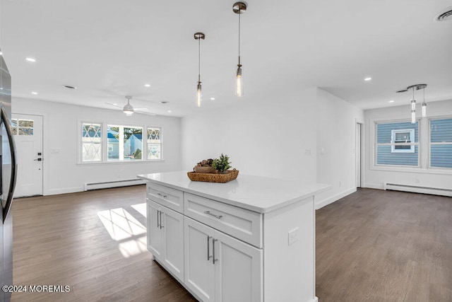 kitchen with dark hardwood / wood-style floors, white cabinetry, hanging light fixtures, and a baseboard heating unit