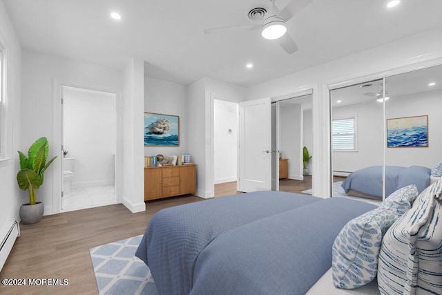 bedroom featuring connected bathroom, hardwood / wood-style flooring, a baseboard radiator, and ceiling fan