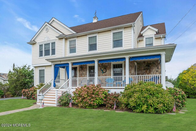 view of front of house with covered porch and a front yard