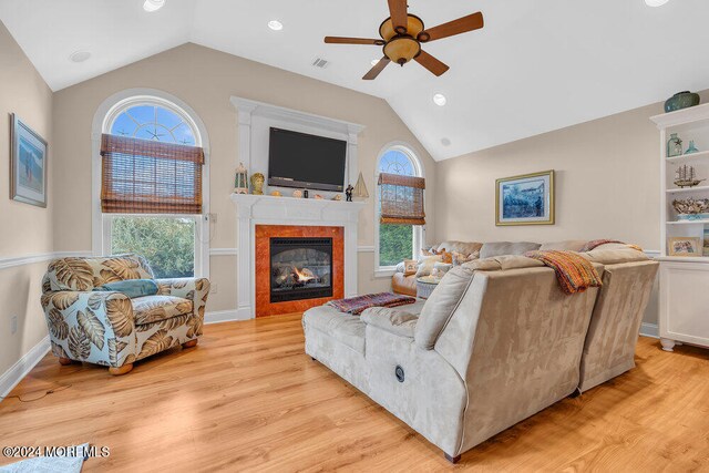 living room featuring light hardwood / wood-style flooring, lofted ceiling, and a healthy amount of sunlight