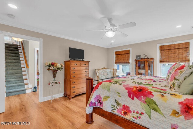 bedroom featuring ceiling fan, light wood-type flooring, and crown molding