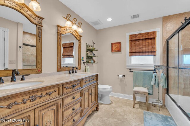 full bathroom with vanity, toilet, and combined bath / shower with glass door