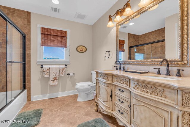 full bathroom with tile patterned floors, enclosed tub / shower combo, vanity, and toilet