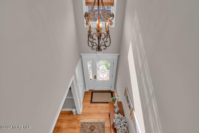 foyer entrance featuring wood-type flooring and a chandelier