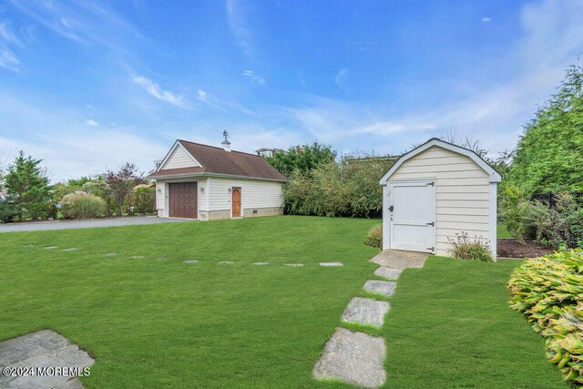 view of yard featuring a garage and a storage unit