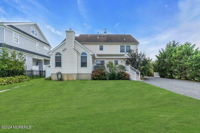 back of property featuring a lawn and a porch