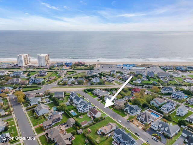 drone / aerial view featuring a water view and a beach view