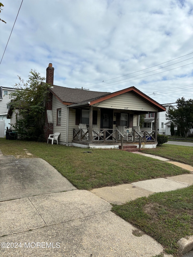 bungalow-style house featuring a front yard and covered porch