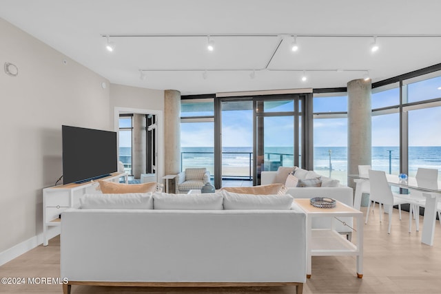 living room with light wood-type flooring and a water view